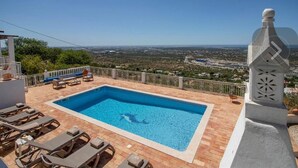 A rectangular pool with a clear blue water surface, surrounded by a tiled deck with lounge chairs. - Carpe Diem (faro)
