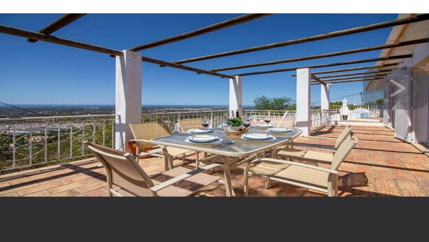 A terrace with a table set for dining, overlooking a cityscape. - Carpe Diem (faro)