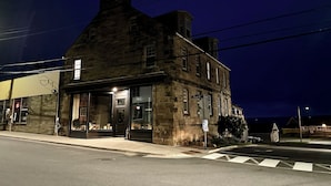 A historic stone building with a prominent entrance and a sign indicating 'Water St.'