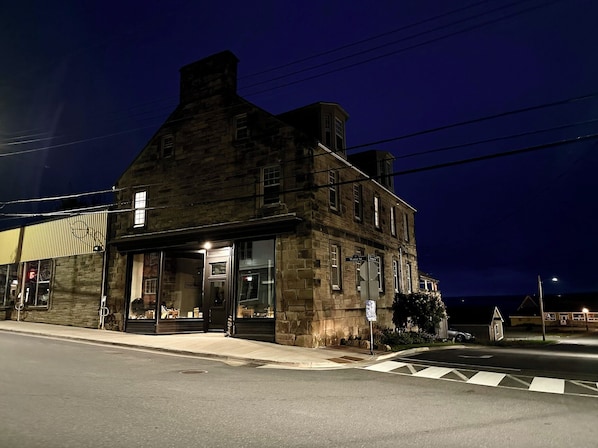 A historic stone building with a prominent entrance and a sign indicating 'Water St.' - The Stonehouse Makers' Maisonette (Pictou)