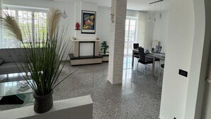 A spacious living area with a modern kitchen in the background, a dining area, and a large window providing natural light. - Cozy apartment within walking distance of the sea, with pets allowed  (Scalo Ferroviario)