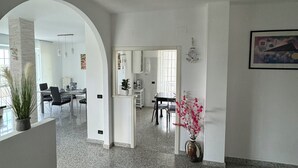 A spacious, well-lit interior with a kitchen, dining area, and a hallway leading to another room. - Cozy apartment within walking distance of the sea, with pets allowed  (Scalo Ferroviario)
