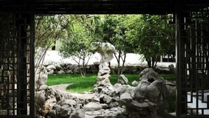 A traditional garden with a rock formation and a wooden gate. - Yangzhou Slender West Lake Huijin Hotel (Yangzhou)