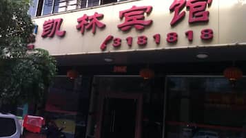A hotel with a signboard displaying the name and contact number.