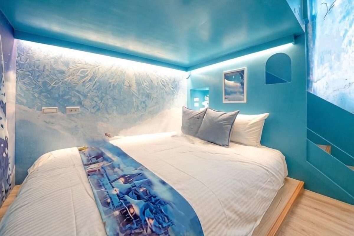 Un dormitorio con una cama, una mesita de noche y una pared con un mural.