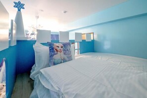 Een slaapkamer met een bed, een kussen met een karakterontwerp, ster decoratie en een raam.