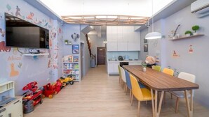 A children's playroom with a TV, toys, and a dining area with chairs. - Yilan 1955 Bnb Second Branch (Yilan)