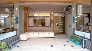 Un hall d’entrée moderne avec un plafond en bois, un espace salon et un comptoir d’accueil.