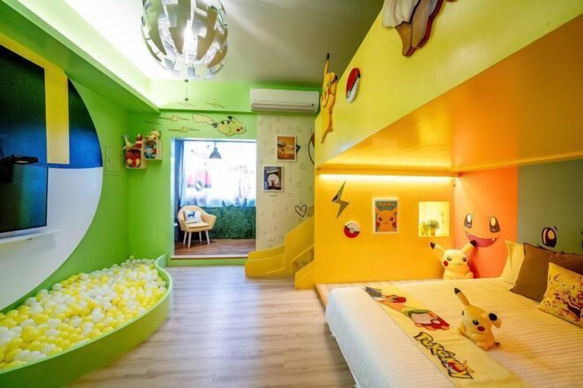 A children's room with a bed, ball pit, and wall decorations.