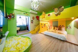 Kinderzimmer mit Bett, Bällebad und Wanddekorationen.
