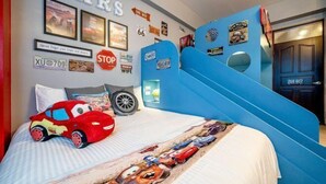 A bedroom with a bed, a blue slide, and various car-themed decorations. - Yilan 1955 Bnb Second Branch (Yilan)