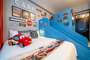 A bedroom with a bed, a blue slide, and various car-themed decorations. - Yilan 1955 Bnb Second Branch (Yilan)