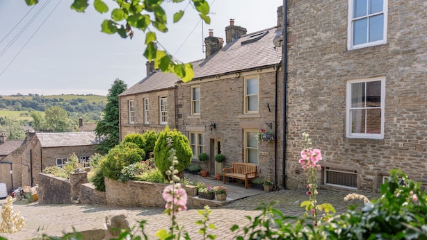 A stone building with a courtyard, a bench, and potted plants. - Danes Cottage – Luxury Peak District Retreat (Chapel-en-le-Frith)
