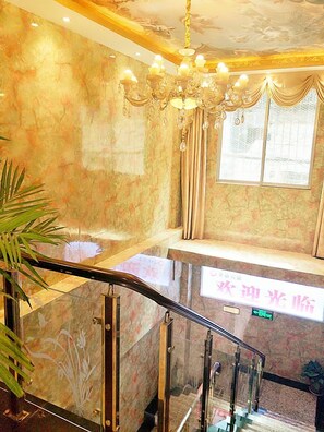 A marble staircase with a glass railing, a chandelier, and a window with curtains. - Dazhou Jindi Hotel (Dazhou)