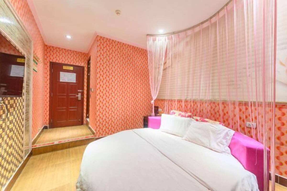 Un dormitorio con una cama, una puerta y una cortina.
