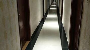 A long, narrow hallway with doors on both sides, leading to rooms.