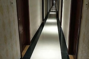 A long, narrow hallway with doors on both sides, leading to rooms. - Dazhou Jindi Hotel (Dazhou)