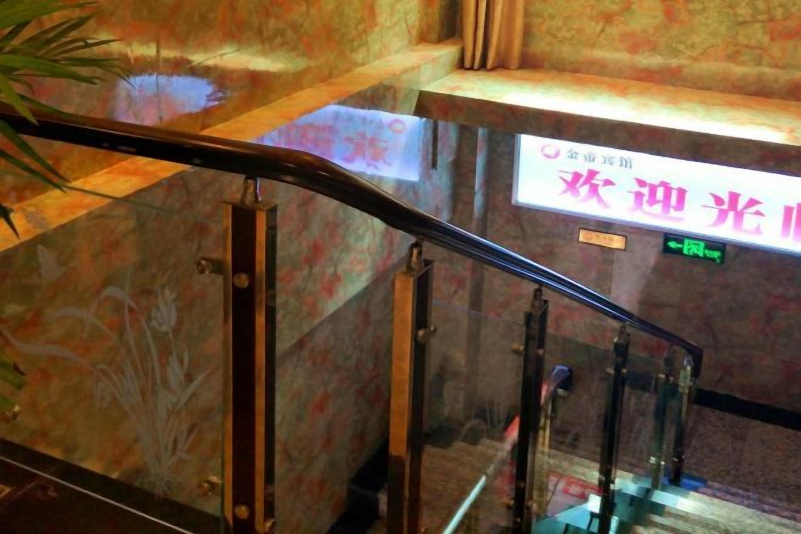 A glass railing with a floral pattern on the wall behind it.