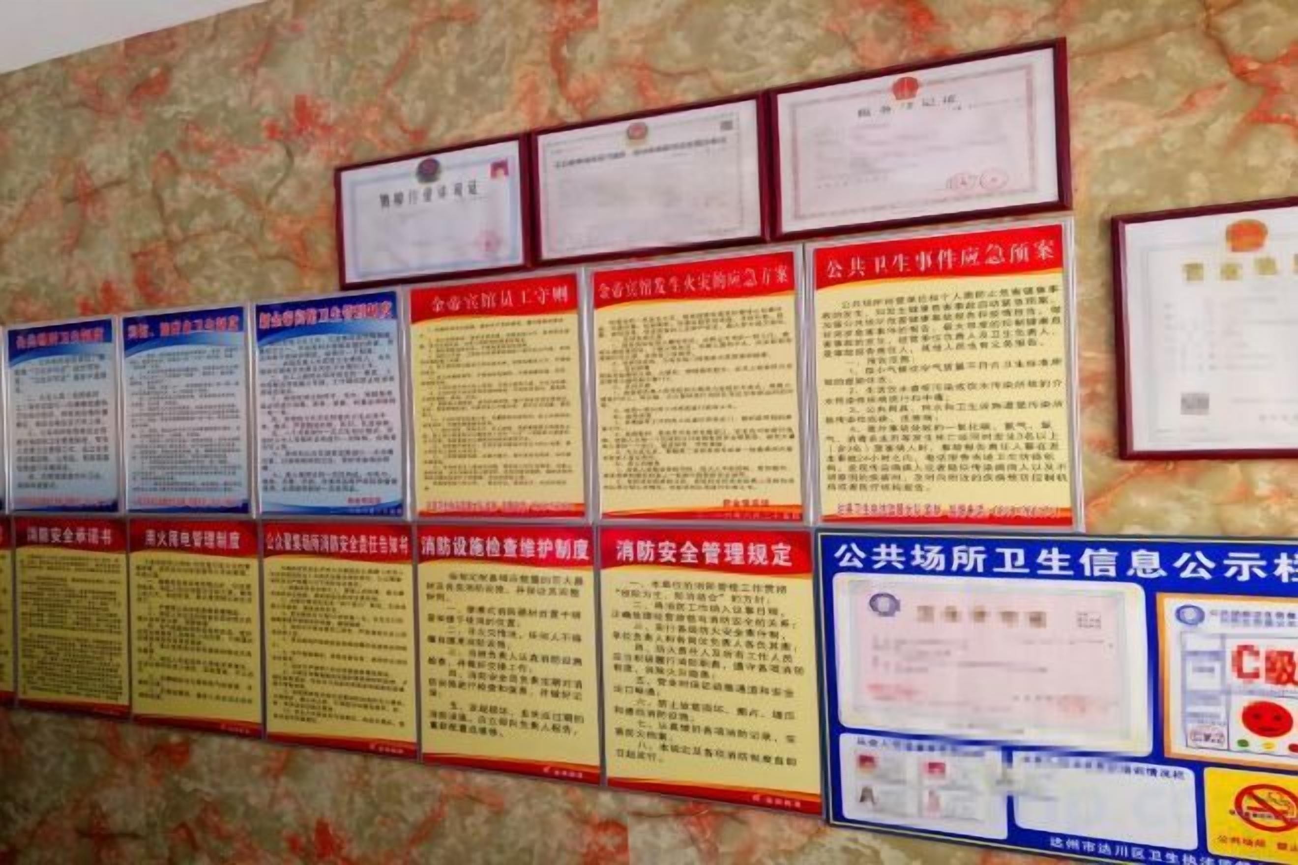 A wall with multiple certificates and informational posters.