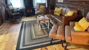 Una sala de estar acogedora con chimenea, muebles de madera y una alfombra.