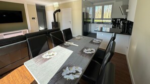 A modern kitchen with a built-in stove, a dining area with a table set for four, and a large window providing natural light.
