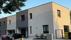 A modern building with a flat facade, multiple windows, and a gated entrance. - Vacation home near Katowice  (Bytom)