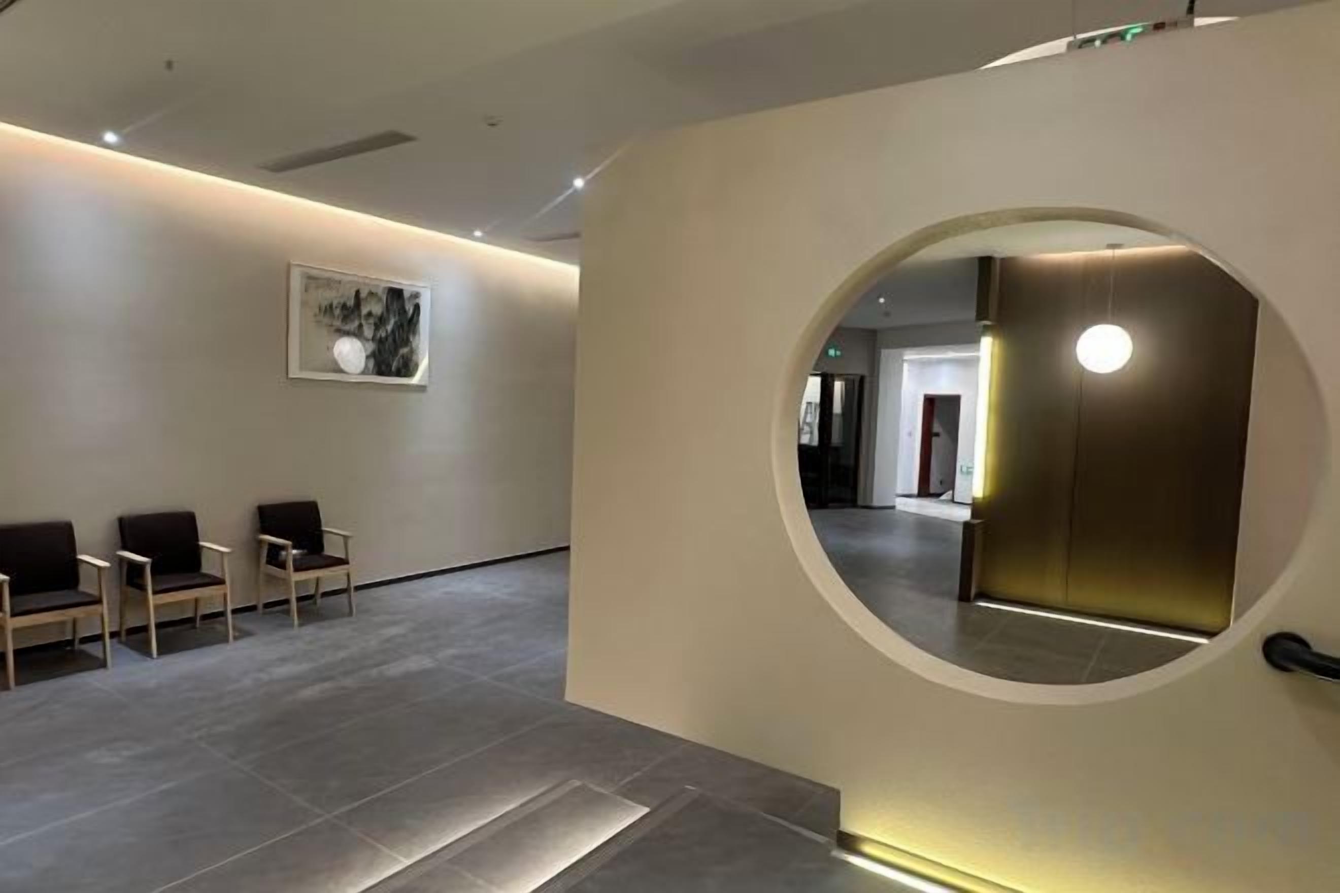 A reception area with a circular wall feature, a reception desk, and a seating area with chairs.