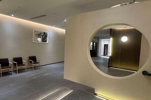 A reception area with a circular wall feature, a reception desk, and a seating area with chairs.