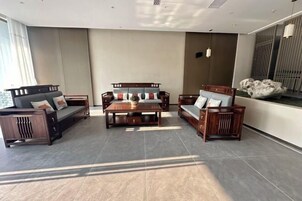 Un amplio salón con un gran sofá, una mesa de centro y un televisor.