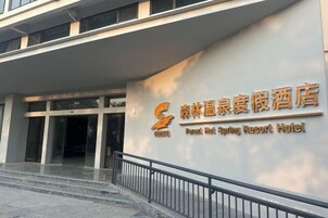 Exterior del Hotel Forest Hot Spring Resort, con una entrada destacada y una vista clara de la señalización.