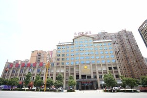 Un edificio de varios pisos con una entrada destacada y señalización.