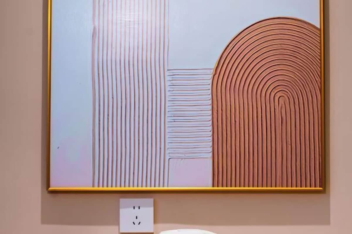 A framed abstract painting with vertical and concentric lines on a light background.