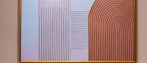 Un cuadro abstracto enmarcado con líneas verticales y concéntricas sobre un fondo claro.