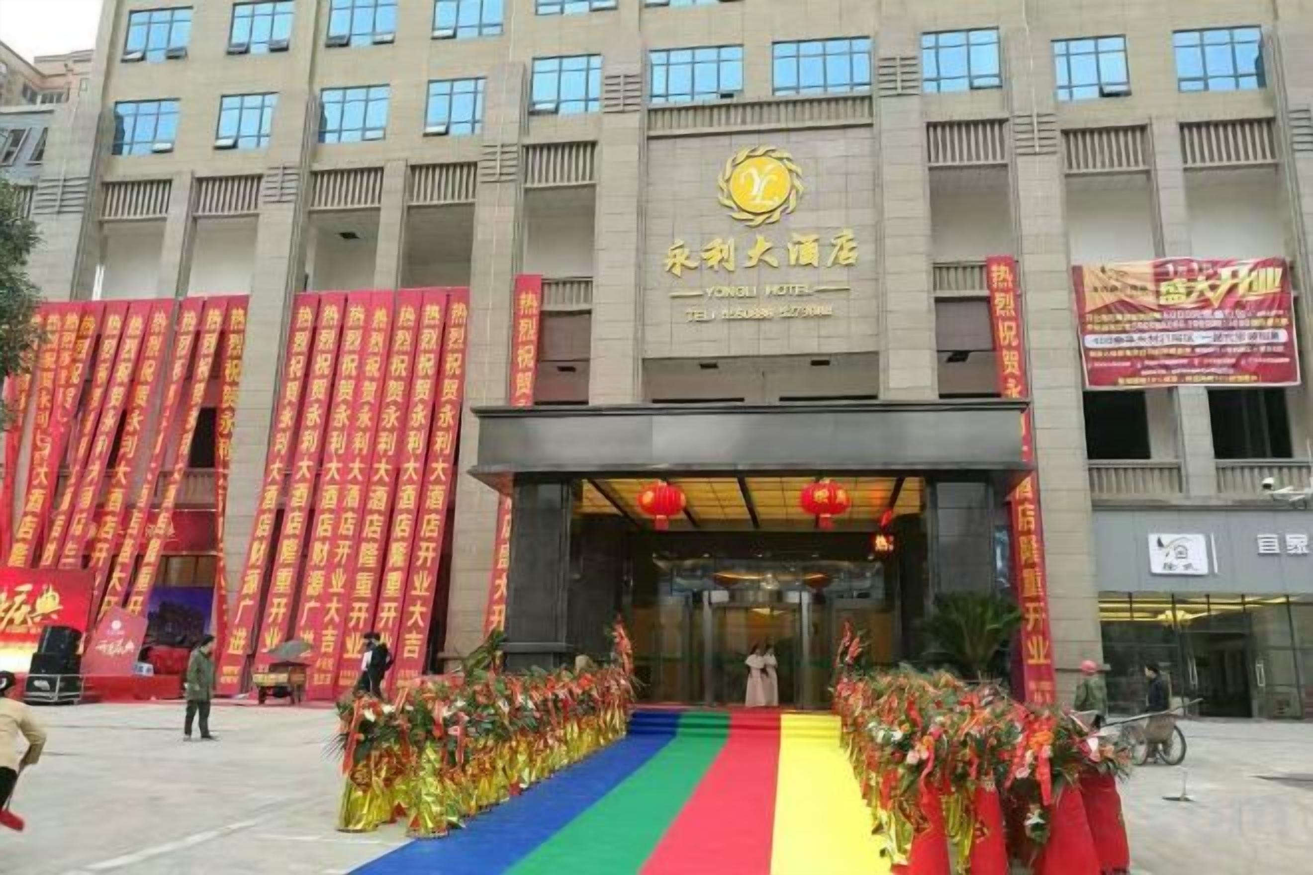 A building with a large entrance, vertical banners, and a red carpet leading to the door.