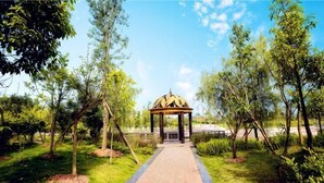 A pathway leading to a gazebo in a park with trees and grass. - Yongli Hotel (Yuechi)