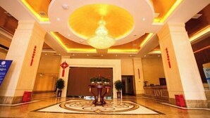 A hotel lobby with a large chandelier, a reception desk, and a decorative floor pattern. - Yongli Hotel (Yuechi)