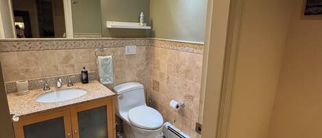 Un baño moderno con tocador, lavamanos e inodoro.