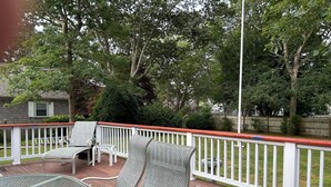 A covered deck with outdoor furniture, a white railing, and a view of the backyard. - Close to BEACH! Falmouth / Falmouth Heights 4Bdr-2Ba. 2025 Renovation Large Deck (Falmouth)