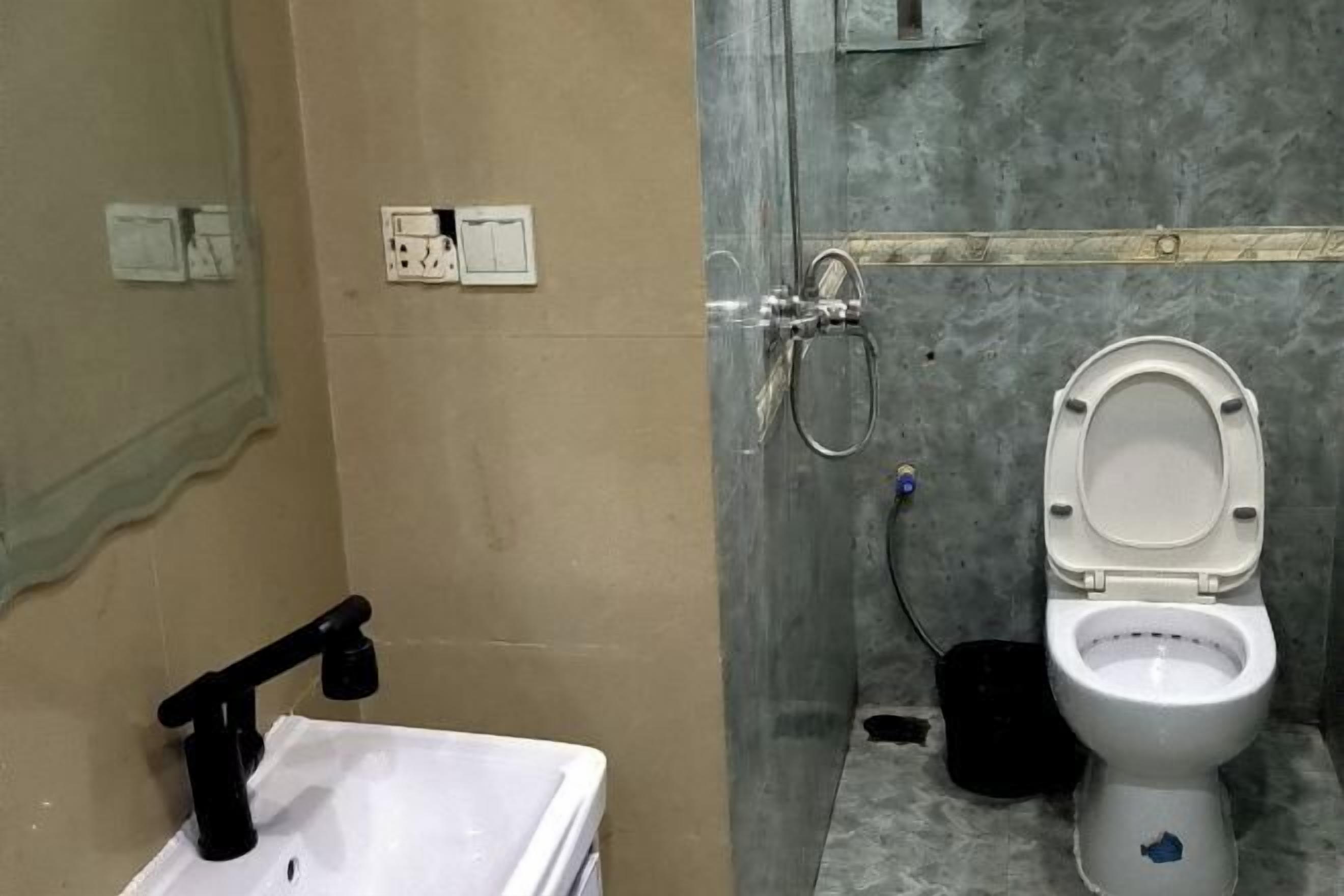A bathroom with a white sink, a toilet, and a shower area.