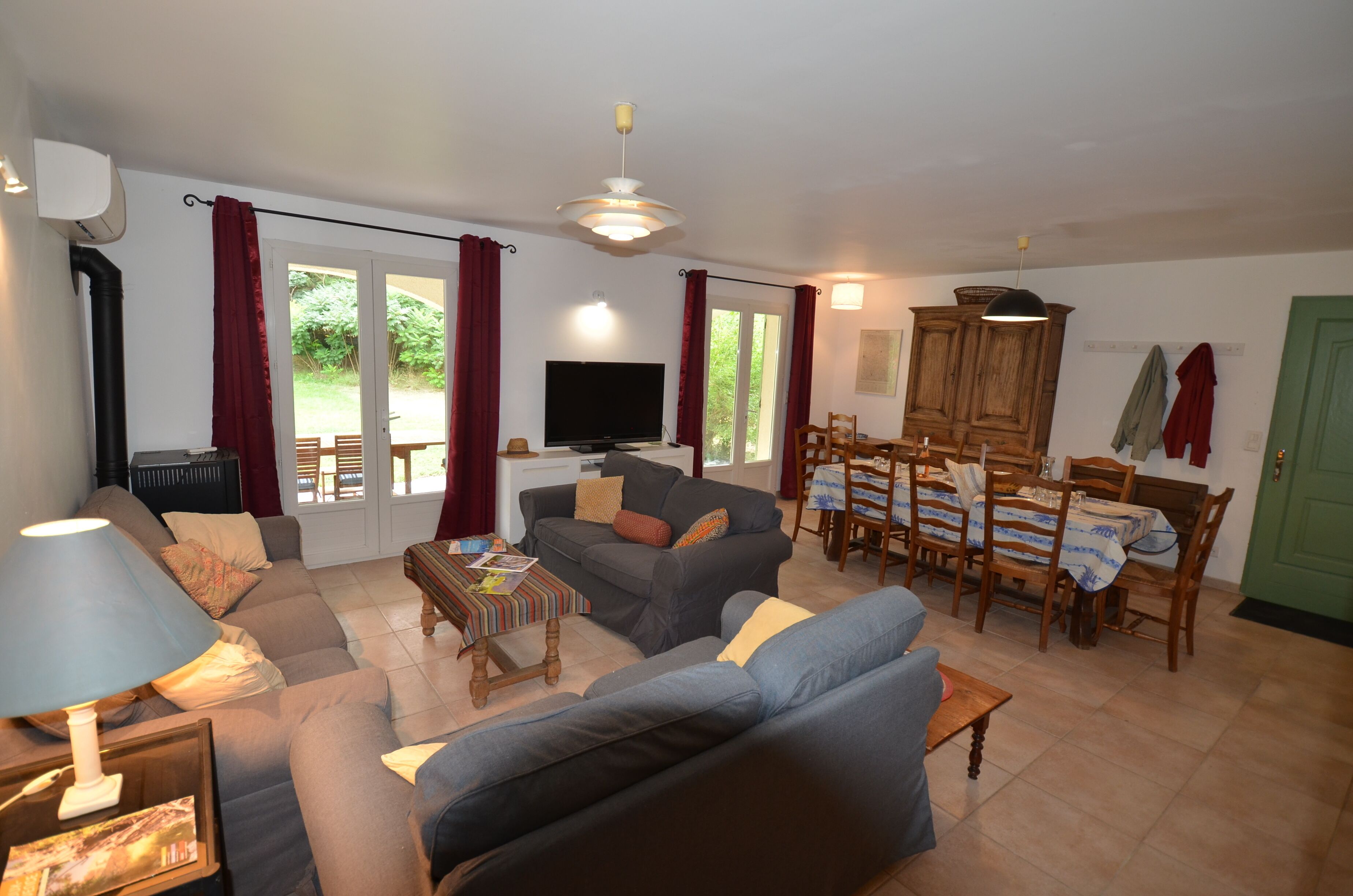 A living room with a sofa set, a television, and a dining area with a table and chairs.