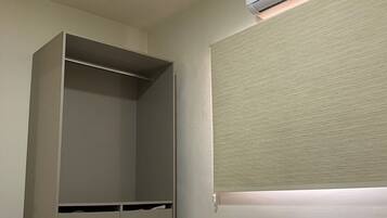 Un dormitorio con cama, armario y aire acondicionado.