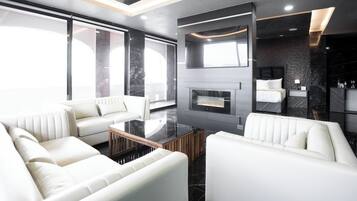 Suite estudio panorámica, vista a la ciudad | Área de sala de estar | Smart TV de 39 pulgadas con canales por cable