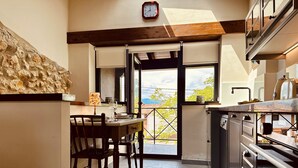 Una cocina con comedor, un reloj en la pared y vistas al exterior.