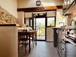 Una cocina con comedor, un reloj en la pared y vistas al exterior.