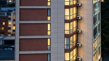 A multi-story building with a modern design, featuring large windows and air conditioning units on the exterior.