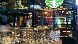 Un Starbucks doté d’une façade moderne en verre et d’un espace intérieur aménagé pour accueillir les clients.