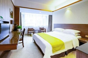 A hotel room with a bed, a desk, a chair, a television, and a window with curtains. - Mingyue Business Hotel(Huaqiang North subway station store) (Shenzhen)