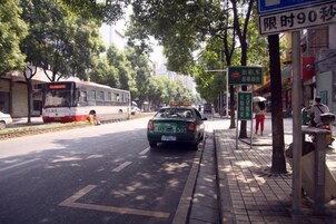 Escena callejera con un tranvía, un taxi y un paso de peatones.