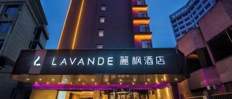 L’entrée d’un hôtel, avec une enseigne bien visible indiquant « LAVANDE » et « LAVANDE HOTEL » en anglais et dans une autre langue.