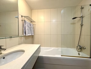 A bathroom with a bathtub, a glass-enclosed shower, a sink, and a towel rack. - Paradise in Santa Maria (Sal)